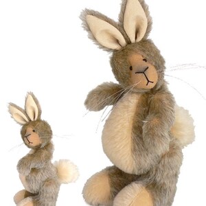 May include: Two plush bunny rabbits, one larger than the other, both with brown fur and cream-colored accents. The larger bunny is sitting with its tail behind it, while the smaller bunny is standing with its tail to the side.