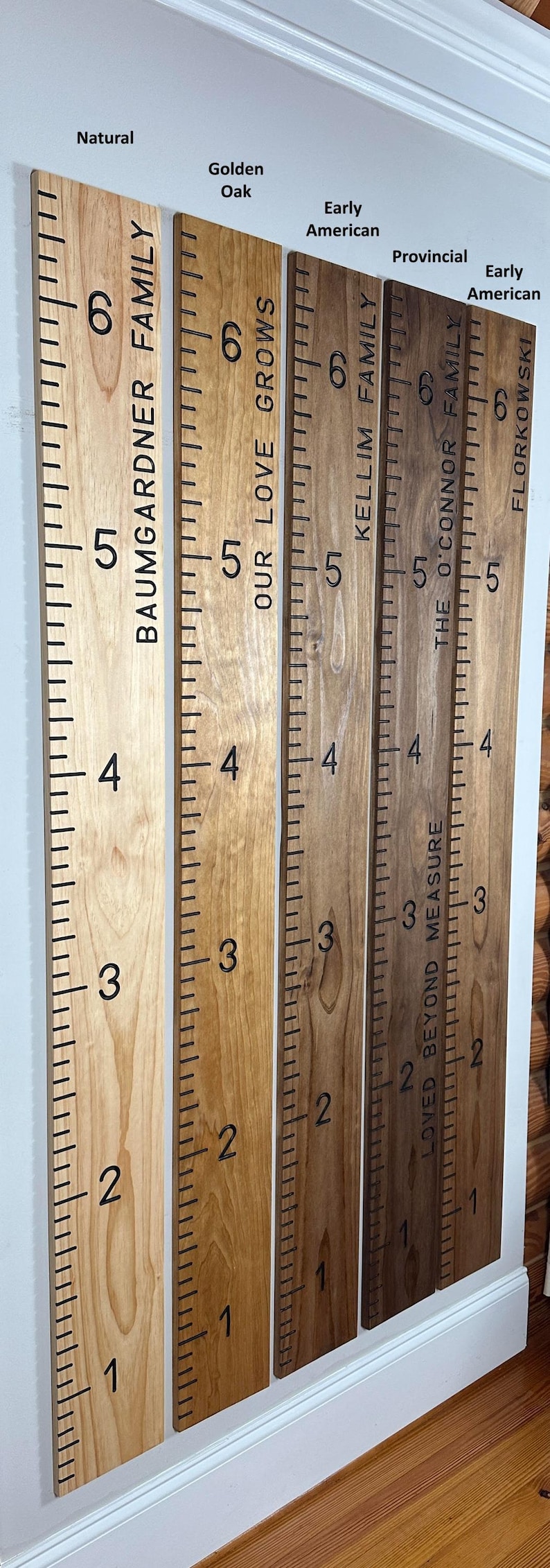 May include: Wooden growth charts in various wood tones, including Natural and Golden Oak. Each chart features family names and measurement markings in inches, from 1 to 6 feet. A decorative and functional home decor item.