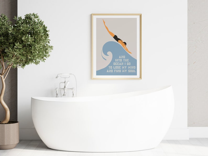 May include: A framed print with a minimalist illustration of a person diving into a blue wave. The text below the image reads "And into the ocean I go to lose my mind and find my soul."