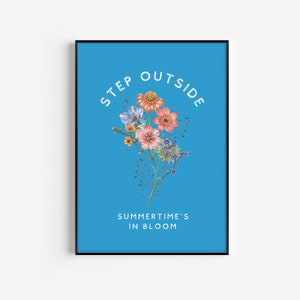 May include: A blue poster with white text that reads "Step Outside Summertime's in Bloom". A bouquet of colorful flowers is in the center of the poster.