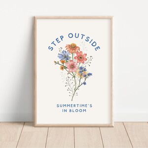 May include: A white framed print with a floral illustration and the text "STEP OUTSIDE SUMMER TIME'S IN BLOOM" in blue.