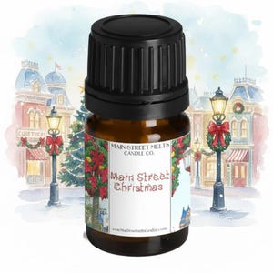 May include: A brown glass bottle with a black cap, labelled "Main Street Christmas" against a festive holiday scene. The label features a Christmas wreath design. The background shows a wintery street scene with buildings and lamp posts.