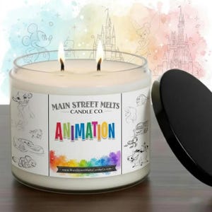May include: A two-wick candle in a clear glass jar with a black lid. The label features the text Main Street Melts Candle Co. and Animation in colourful letters, surrounded by line art of various animated characters and a rainbow watercolour splash.