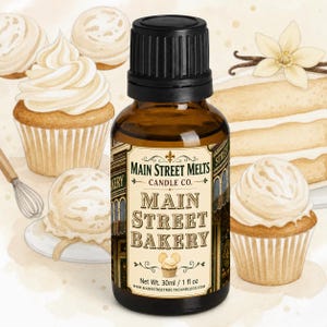 Könnte beinhalten: Eine braune Glastropfflasche mit schwarzem Verschluss und einem Etikett mit der Aufschrift Main Street Melts Candle Co. Main Street Bakery, mit einem Nettogewicht von 30 ml / 1 fl oz. Das Etikett enthält eine kleine Cupcake-Grafik und Ränder.