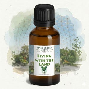 May include: An amber glass bottle with a black screw-top cap featuring a white label. The label displays the text Main Street Melts Candle Co., Living With The Land, a small green topiary icon, and the website address www.MainStreetMeltsCandleCo.com.