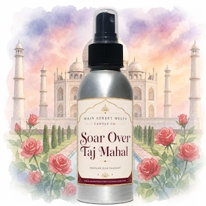 May include: A silver spray bottle with a black nozzle and a rectangular label featuring the text Main Street Melts Candle Co. Soar Over Taj Mahal Prepare For Takeoff. The label design includes decorative gold lines and a floral border.