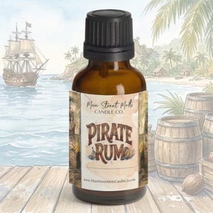 May include: A small amber glass bottle with a black dropper cap. The label features the text Main Street Melts CANDLE CO. and PIRATE RUM in a stylized font. The label design includes illustrations of a wooden barrel and a small anchor.