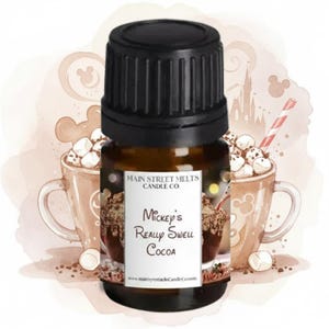 May include: A brown glass bottle with a black cap. The label reads "Mickey's Really Swell Cocoa" from Main Street Melts Candle Co. The background features illustrations of cocoa mugs, marshmallows, and a castle.