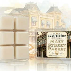 May include: A six-cube wax melt tray in a clear plastic clamshell container. The wax is off-white. A rectangular label features the text Main Street Melts Candle Co. Main Street Bakery with an illustration of a bakery storefront and a cupcake.