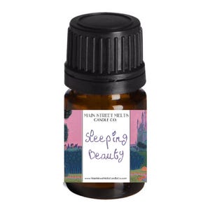 May include: A small brown glass bottle with a black lid. The bottle has a label that says "Main Street Melts Candle Co." and "Sleeping Beauty". The label has a pink background with a castle and trees.