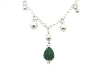 May include: A silver necklace with a green malachite pendant and silver beads. The necklace has a delicate chain and a teardrop-shaped pendant.