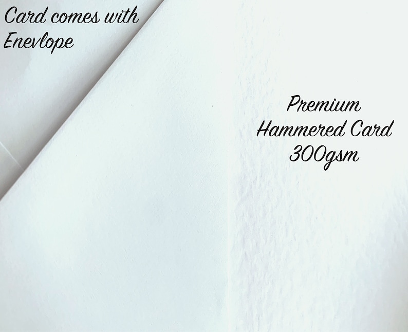 以下が含まれることがあります： 「Card comes with Envelope」と「Premium Hammered Card 300gsm」の文字が入った白いカードのクローズアップ。カードはテクスチャ加工された表面で、画像では斜めに配置されています。