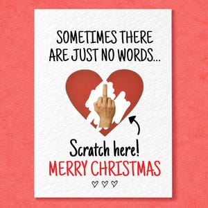 May include: A white greeting card with black text reading SOMETIMES THERE ARE JUST NO WORDS... above a red heart. Inside the heart is a scratch-off area revealing a hand giving the middle finger. Below is text reading Scratch here! MERRY CHRISTMAS.