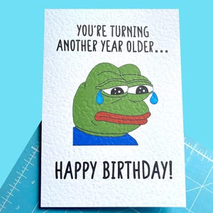 Sad Frog Viral Meme Tarjeta de Saludo - Pepe La Rana - Feliz Cumpleaños - Eres un año mayor... - Tarjeta Humorística - Meme Divertido