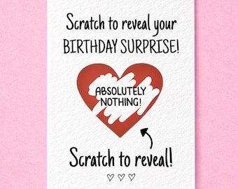 May include: A white rectangular greeting card featuring black text that reads Scratch to reveal your BIRTHDAY SURPRISE! A large red heart is in the center with white scratch-off material revealing the text ABSOLUTELY NOTHING! with Scratch to reveal! below.