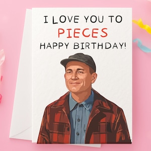 May include: A birthday card with the text "I LOVE YOU TO PIECES HAPPY BIRTHDAY!" features an illustration of a man wearing a cap, blue shirt, and red plaid jacket. The card is white with a white envelope.