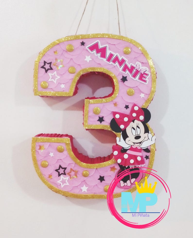 Puede incluir: Pi&ntilde;ata rosa con forma de n&uacute;mero 3 con borde de purpurina dorada, detalles de estrellas y puntos, y un gr&aacute;fico de Minnie Mouse. La palabra "Minnie" se muestra en la pi&ntilde;ata. Pi&ntilde;ata decorativa para una fiesta de cumplea&ntilde;os.