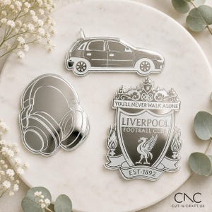 以下が含まれることがあります： ハッチバック車、オーバーイヤーヘッドホン、そして「You'll Never Walk Alone」「Liverpool Football Club」「Est 1892」の文字が入ったリバプールFCのエンブレムをかたどった、銀色の反射性アクリルオーナメント3点。