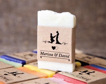 May include: A set of small, rectangular bars of soap wrapped in brown paper with a black silhouette of a couple getting married and the text "Marissa & David".