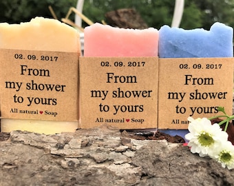 May include: Three bars of soap wrapped in brown paper with a label that reads "From my shower to yours" and "All natural Soap". The soap bars are yellow, pink, and blue.