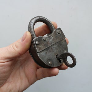 May include: A white ceramic mug with a black handle and the text "But First, Coffee" in a black, handwritten-style font. The mug is on a white surface.