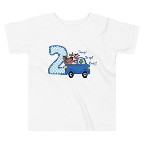 May include: A white t-shirt with a blue number two and a blue truck with farm animals. The truck has the words "Beep! Beep! Beep!" written on it.