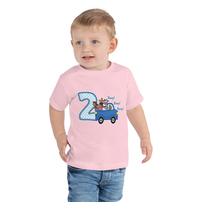 May include: Pink toddler t-shirt with a blue number 2 and a blue truck with farm animals. The truck has the words "Beep! Beep! Beep!" on the side.