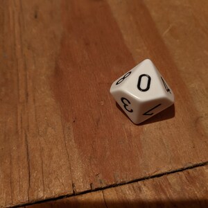 May include: A white, six-sided die with black numbers. The die is showing the number 6.