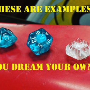 Peut inclure: Trois dés, deux bleus et un transparent. Les dés bleus ont des chiffres blancs. Le dé transparent a des chiffres noirs. Le texte "These are examples" est en haut de l'image et le texte "You dream your own" est en bas de l'image.