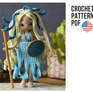 Könnte beinhalten: Eine Häkelpuppe mit langem cremefarbenem Haar und blauen schlangenartigen Akzenten, bekleidet mit einem hellblauen Kleid und einem goldenen Gürtel. Die Puppe hält einen hohen goldenen Stab mit einem blauen Edelstein und einen runden blauen Schild. Text: CROCHET PATTERN PDF.