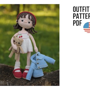 May include: A crochet doll with brown hair wearing a red beret, a white dress with cherry embroidery, white socks, and red shoes. The doll holds a small brown teddy bear and stands next to a light blue crochet jacket. Text reads OUTFIT PATTERN PDF.