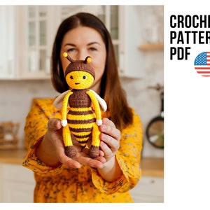 Op de afbeelding: Haakpatroon PDF voor een schattig amigurumi-bijspeelgoed. De bij is geel en bruin met zwarte strepen en witte vleugels. Het patroon is beschikbaar om te downloaden.