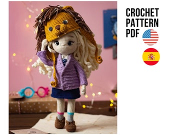 May include: Crochet pattern PDF for a doll wearing a purple sweater, blue skirt, and a lion hat. The pattern is available in English and Spanish.