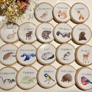 May include: A set of 16 wooden circles with animal illustrations and words representing character traits, such as Attentiveness, Generosity, Gratitude, Humility, Courtesy, Honesty, Obedience, Patience, Gentleness, Perseverance, Love, Helpfulness, Respect, Compassion, Optimism, Kindness, Self-Control, and Creativity.