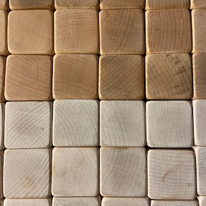 May include: A close-up of a set of wooden blocks, arranged in a grid pattern. The blocks are made of natural wood and have a light brown color. The blocks are smooth and have a slightly textured surface.