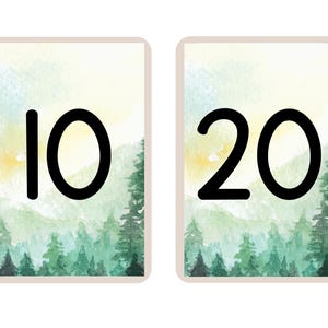 May include: Two rectangular cards with a watercolor forest scene background. The card on the left has the number 10 in bold black font, and the card on the right has the number 20 in bold black font. The cards have a light beige border.