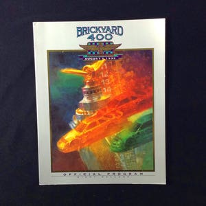 May include: A program cover for the Brickyard 400 race, held on August 5, 1995. The cover features a colorful illustration of a race car and a trophy.