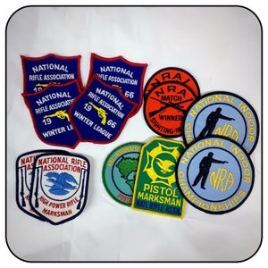 May include: A collection of nine embroidered patches featuring the National Rifle Association (NRA) logo. The patches are in various colors, including red, blue, green, and yellow. Some patches feature the NRA logo, while others feature the words "National Rifle Association", "NRA Match", "Pistol Marksman", and "National Indoor Championships".