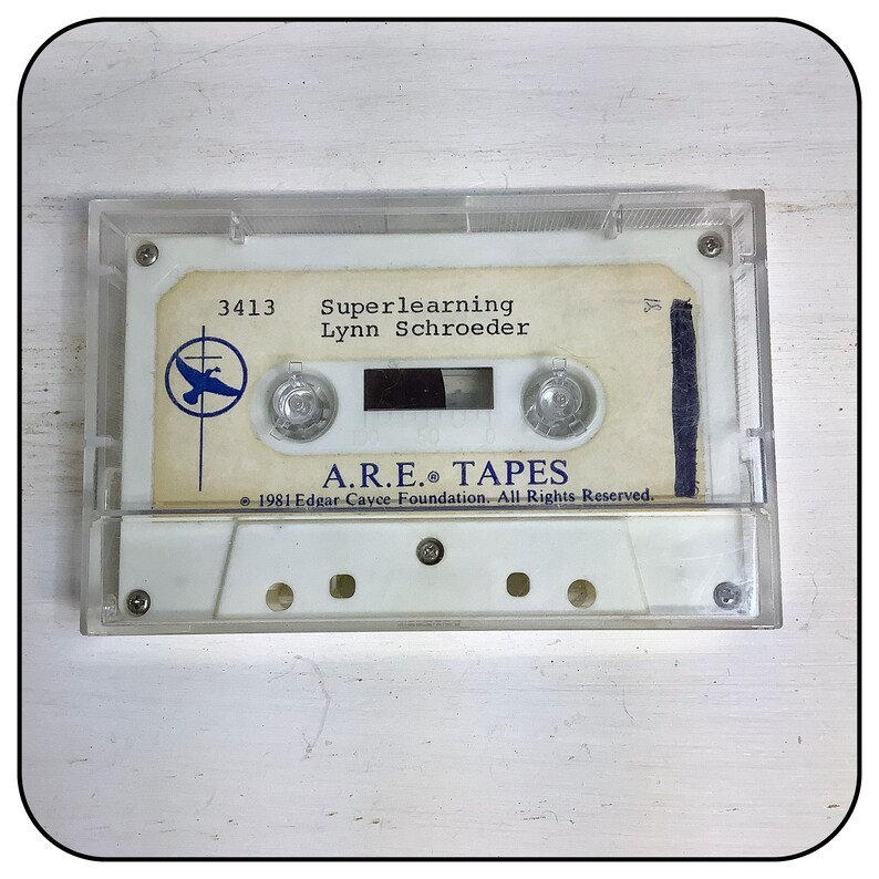 May include: A clear plastic cassette tape case containing a white cassette tape with a cream-colored label. The label features the text 3413, Superlearning, Lynn Schroeder, A.R.E. TAPES, and 1981 Edgar Cayce Foundation. A blue bird logo is visible.
