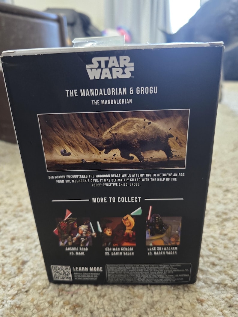 Puede incluir: Una caja negra de figuras de acci&oacute;n de Star Wars con "The Mandalorian & Grogu". La caja incluye una imagen de una bestia Mudhorn y texto que describe la escena. Im&aacute;genes adicionales muestran otros personajes para coleccionar.