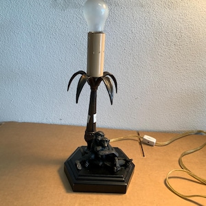 Monos vintage sobre base de lámpara de 30 cm de altura con acabado en latón antiguo.