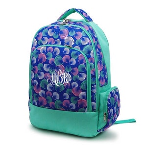 May include: A teal blue backpack with a seashell pattern and a white monogram "BR". The backpack has a large main compartment, a front pocket, and a side pocket.