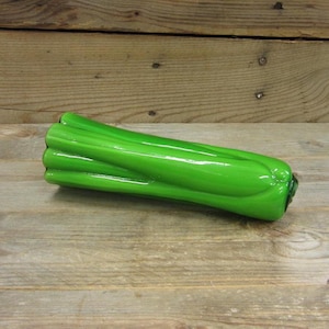 May include: A green glass celery stalk, a decorative piece for a kitchen or home.