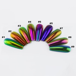 May include: Nine iridescent nail tips arranged in a semi-circle. Each tip is a different colour, ranging from green to purple, with a metallic sheen. The tips are numbered from #1 to #9.