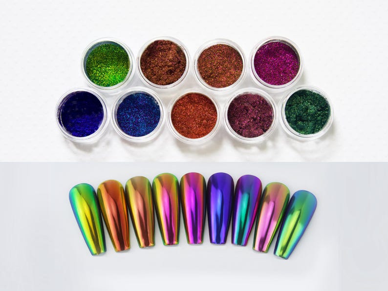 May include: A selection of nail art products. Ten small, clear pots contain glitter powders in shades like green, brown, and purple. Below, ten iridescent nail tips are displayed, showing a range of colours.