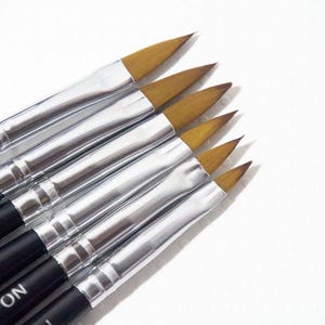 May include: A set of six angled paint brushes with black handles and silver ferrules. The brush tips are a light brown color. The handles are labeled with the number 4.