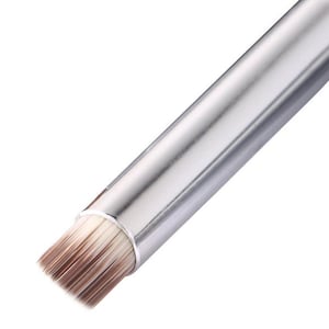 May include: A silver makeup brush with a flat, rectangular brush head. The bristles transition from white to brown. The brush has a metallic silver handle.