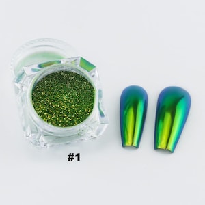 May include: A clear, faceted jar filled with sparkling green glitter, next to two iridescent nail art samples. The samples shift from blue to green. The number "#1" is printed in black on the surface.