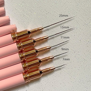 May include: Pink and gold nail art tools with varying tip lengths, labelled 25mm, 15mm, 11mm, 9mm, and 7mm. The tools have pink handles and gold-coloured metal accents.