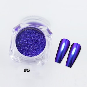 May include: A clear, faceted jar filled with vibrant, sparkling purple nail powder. Two long, oval-shaped nail tips with a metallic, iridescent purple finish are displayed next to the jar. The number "#5" is printed in white.